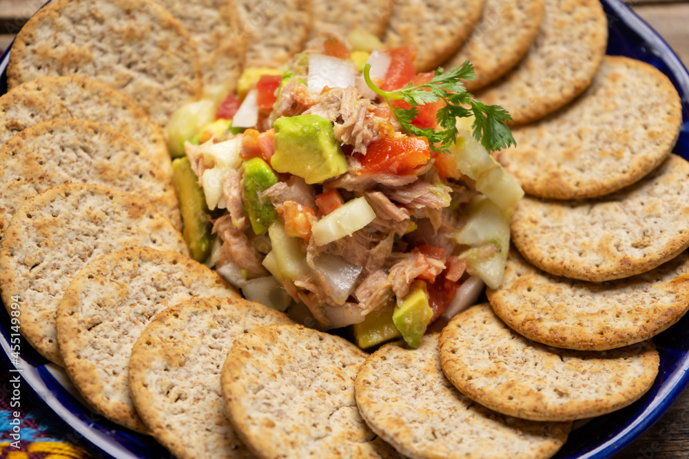 Tuna salad with avocado and cucumber on wooden background Tuna salad with avocado and cucumber on wooden background