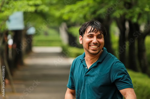 portrait of a smiling model walking in a green park. © Sandeep T2