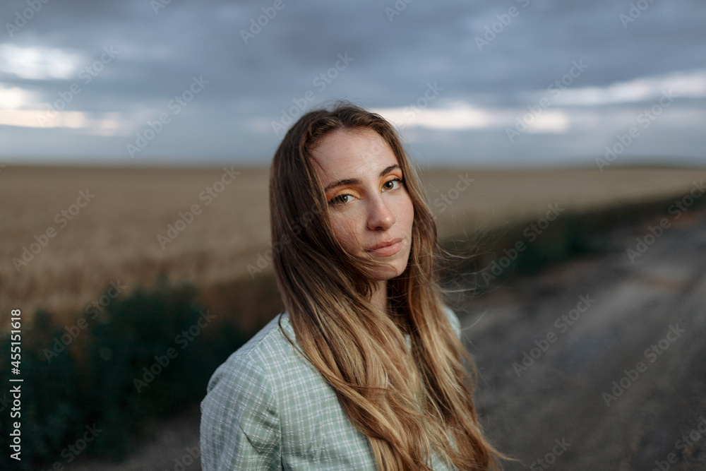 Stylish model in field under cloudy sky Stylish model in field under cloudy sky