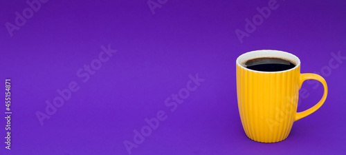 Yellow coffee cup on a fashionable purple background. The concept of the word "Happy Friday".