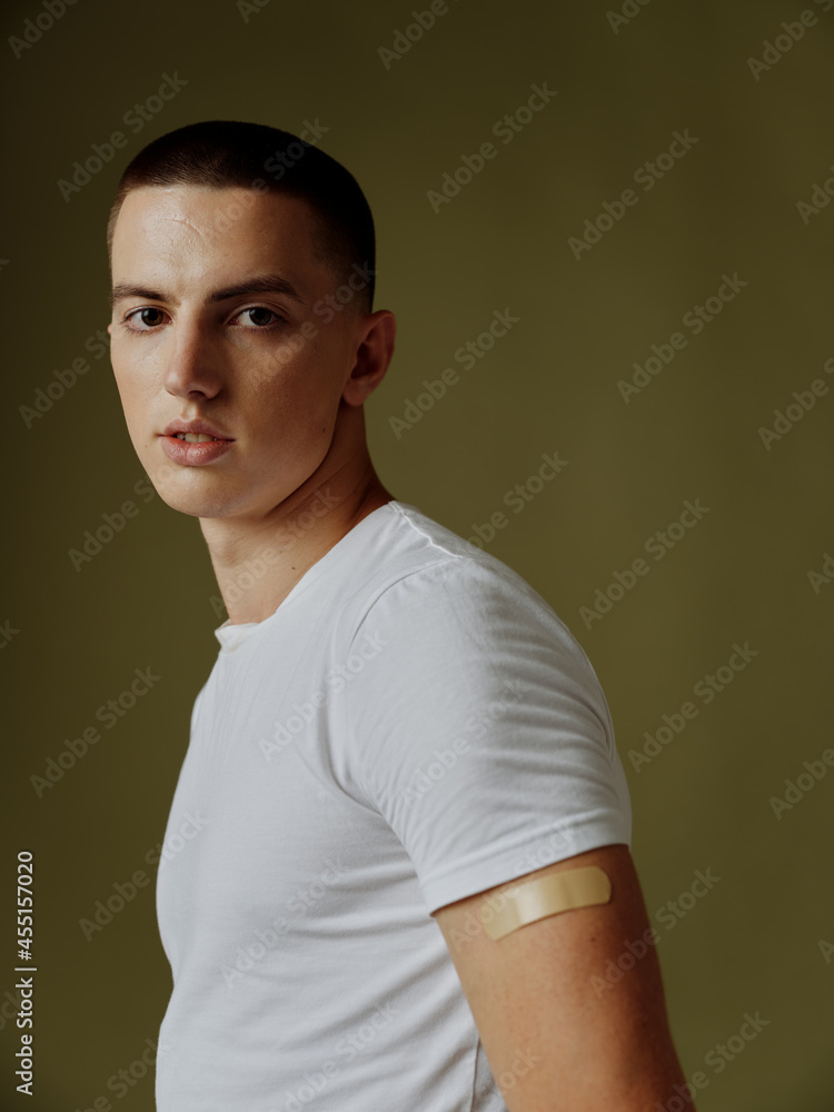 portrait of a man in a white t-shirt with an adhesive plaster on his shoulder vaccination immunity covid passport portrait of a man in a white t-shirt with an adhesive plaster on his shoulder vaccination immunity covid passport