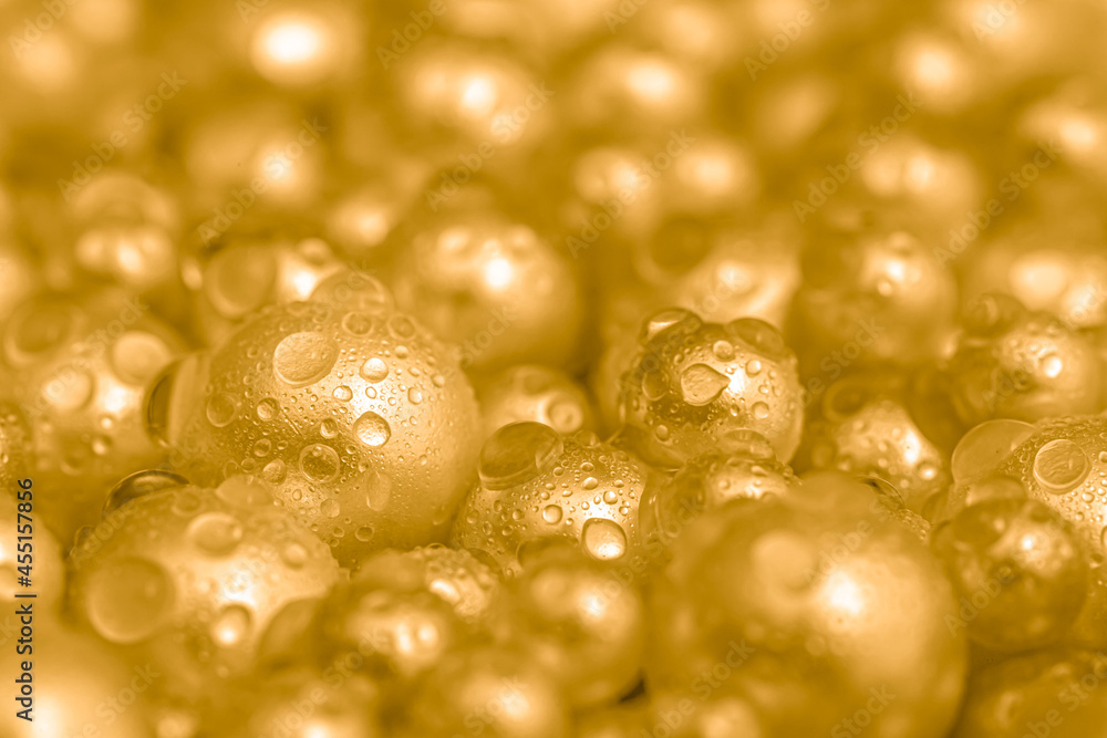 Beautiful background with pearl gold pearls, top view. Abstract texture for festive backgrounds. Shiny yellow surface of Christmas decorations. Gems close-up. Golden bright background. Beautiful background with pearl gold pearls, top view. Abstract texture for festive backgrounds. Shiny yellow surface of Christmas decorations. Gems close-up. Golden bright background.