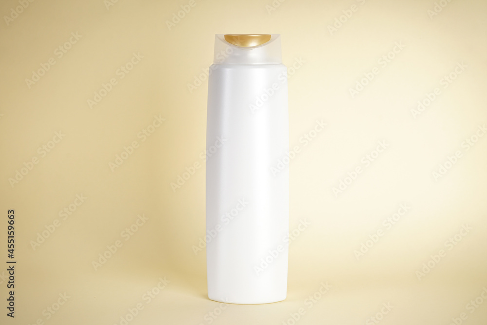 White bottle of shampoo on a yellow background. White bottle of shampoo on a yellow background.