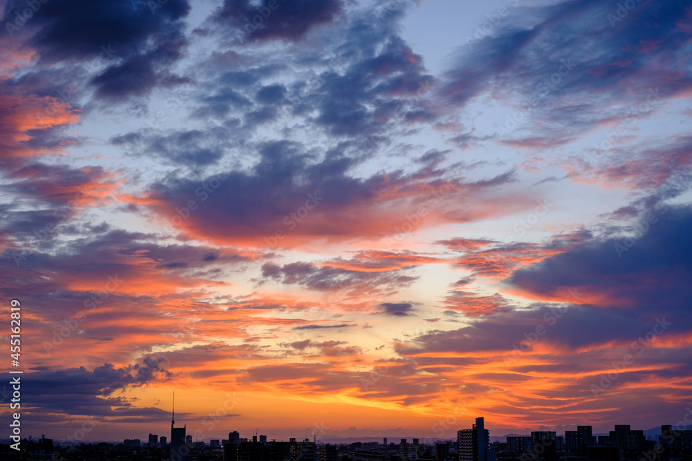 都会の夜明け。神戸市街地から日の出を撮影。雲と空がオレンジ色に染まる