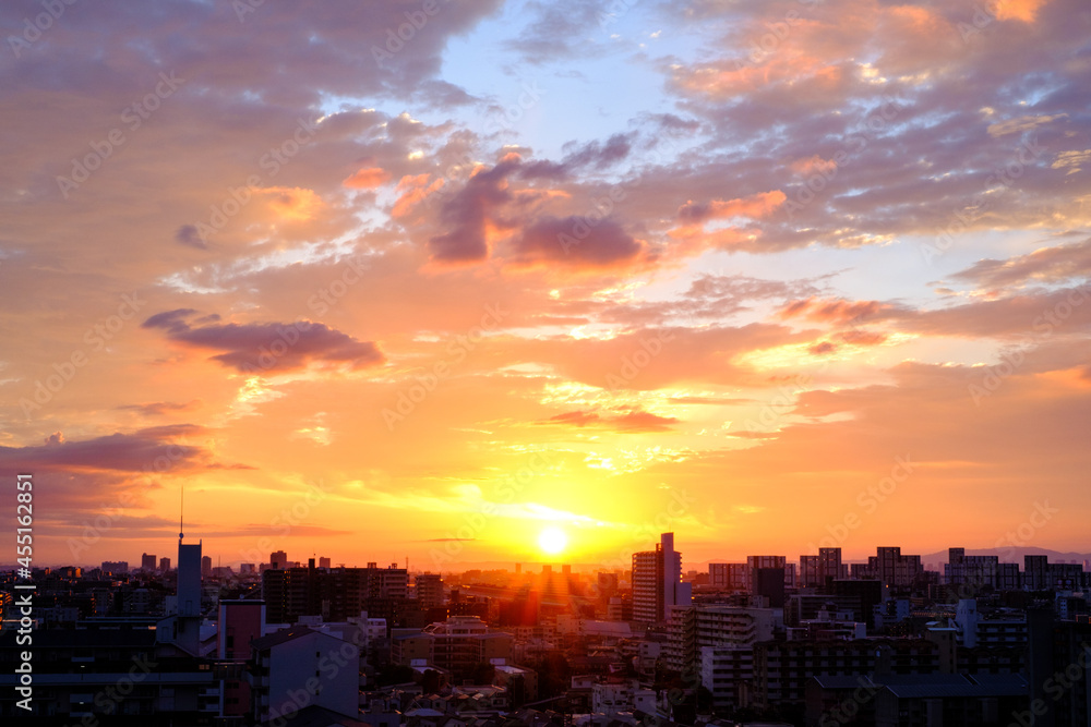 都市の夜明け 日の出とともに空と雲がオレンジ色に染まり ビル群はシルエットとして写す Stock Foto Adobe Stock