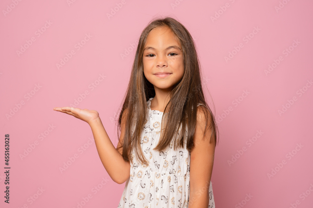 Kid happy smiling face show something on open palm copy space. Girl demonstrate product. Advertisement and commercial concept. Kid happy smiling face show something on open palm copy space. Girl demonstrate product. Advertisement and commercial concept.
