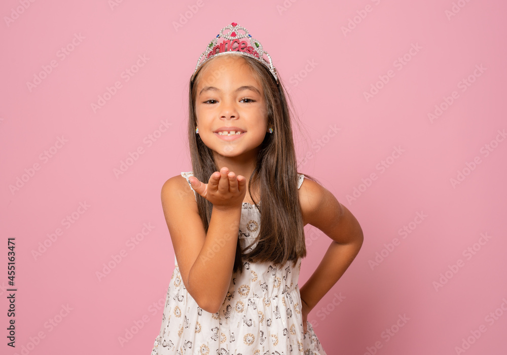 adorable happy smiling little child girl in crown princess celebrating on pink background sending a kiss. birthday party. adorable happy smiling little child girl in crown princess celebrating on pink background sending a kiss. birthday party.