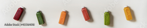 Flat-lay of fresh natural organic juices in bottles, wide composition photo