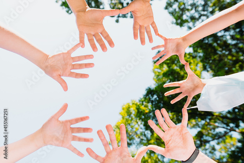 Picture from above of the people hands turned with their palms in the circle towards the camera, they are united in support of freedom from the virus, pandemic concept.