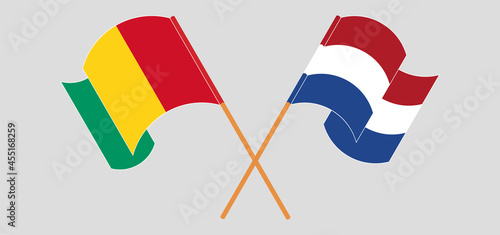 Crossed and waving flags of Guinea and the Netherlands