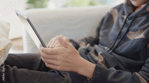 Preteen teen boy hands holding digital tablet at home, using online virtual class , social distancing, homeschooling, remote learning, new normal concept