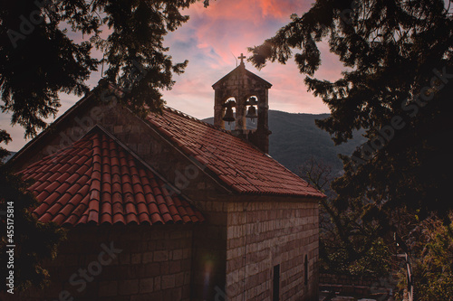 Bells and roof of a small church in the mountains during sunset photo