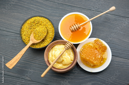 Fresh flower honey of different varieties, pollen and honeycomb with spoons on a wooden background. Organic Vitamin Health Food