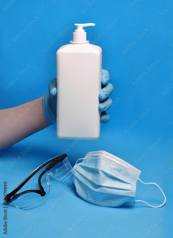 Protective face mask, eyewear, gloves and hand sanitizer on blue background. Protective face mask, eyewear, gloves and hand sanitizer on blue background.