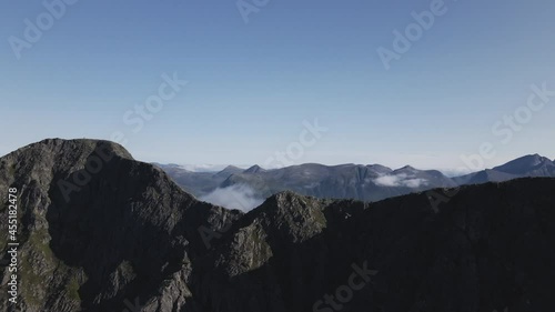 Craggy Mountain Ridge With Low Clouds In Romsdalen. Hiking Destination In Norway. drone shot photo