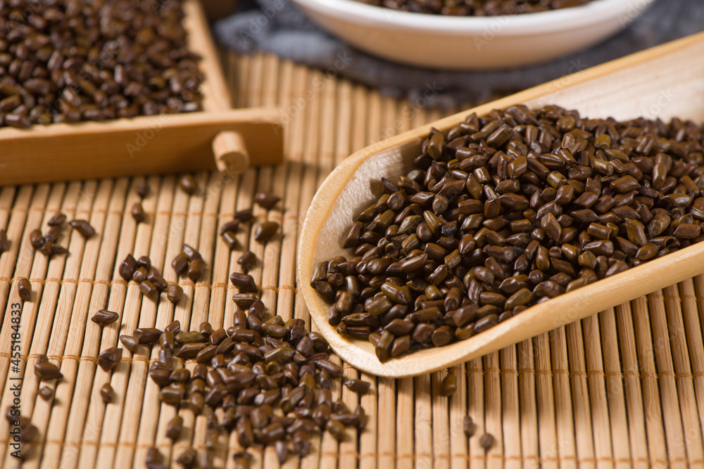 Chinese herbal medicine cassia seeds on wood background Chinese herbal medicine cassia seeds on wood background