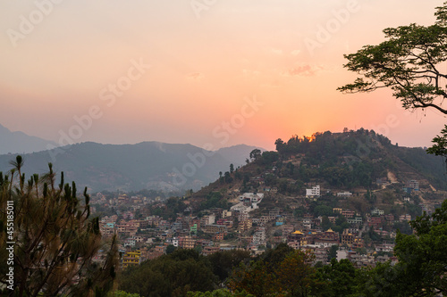 ネパール カトマンズのスワヤンブナート寺院のある丘から見えるカトマンズ盆地と夕焼けでオレンジに染まった空