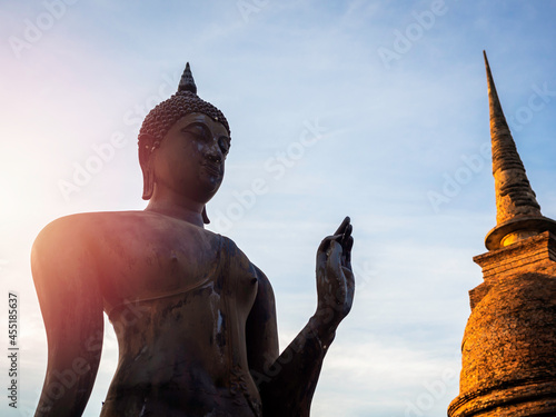 Photography Amazing scene of silhouette of buddha statue and old ancient pagoda at Wat Sra Sri And Tra Pang Tra Kuan temple in the precinct of Sukhothai Historical Park, a UNESCO World Heritage Site in Thailand