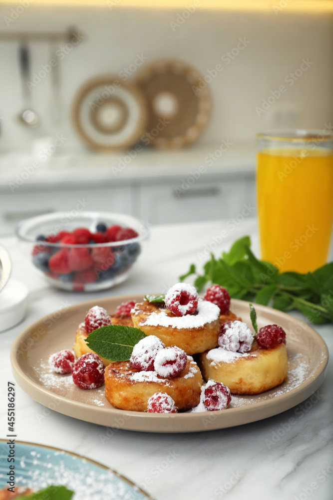 Delicious cottage cheese pancakes with fresh raspberries, mint and icing sugar on white table