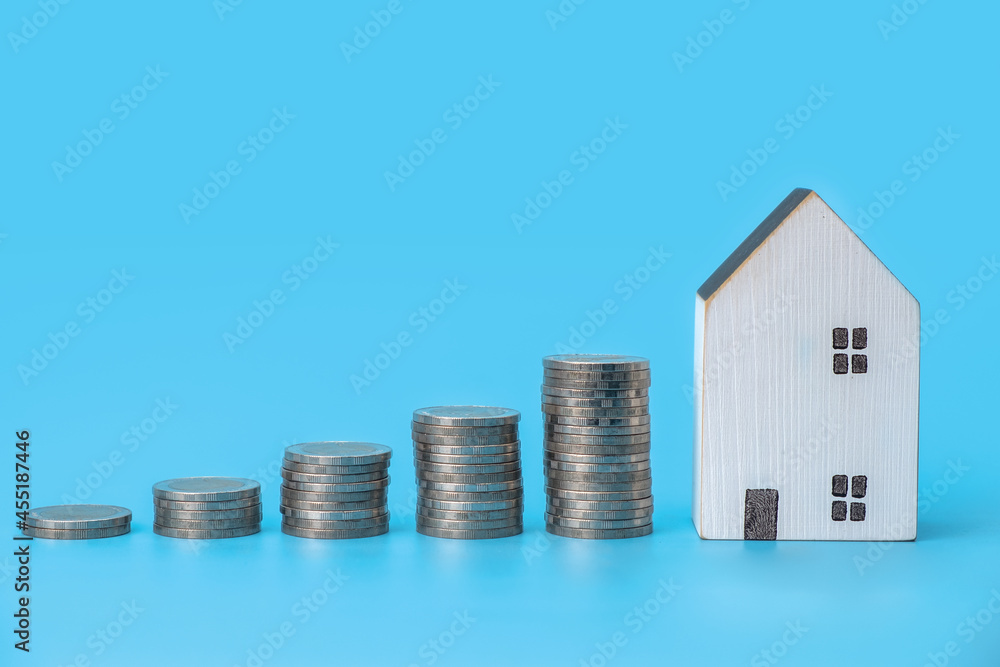 Money stack step up growing growth and mini house on blue background, prepare money for new house, family plan, home, loan, money investment concept. Money stack step up growing growth and mini house on blue background, prepare money for new house, family plan, home, loan, money investment concept.