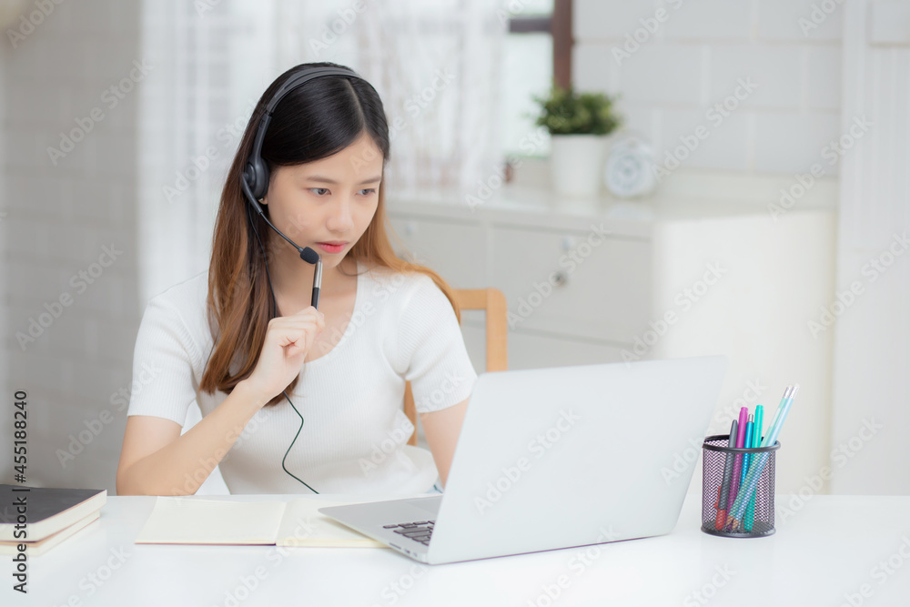 Young asian woman wearing headphone study online with e-learning on desk, girl wearing headset learning to internet with laptop computer at home, new normal, distance education and training. Young asian woman wearing headphone study online with e-learning on desk, girl wearing headset learning to internet with laptop computer at home, new normal, distance education and training.