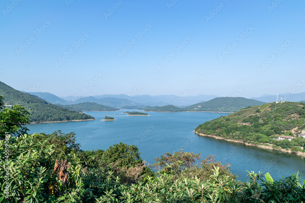 Under the blue sky, the lake is surrounded by mountains and forests