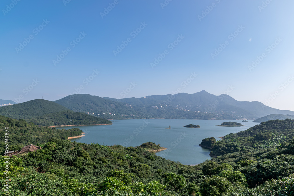 Under the blue sky, the lake is surrounded by mountains and forests
