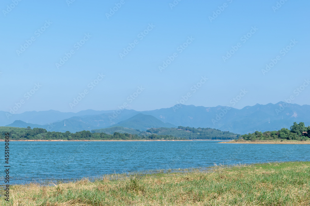 Opposite the lake is a mountain and the shore is a grassland