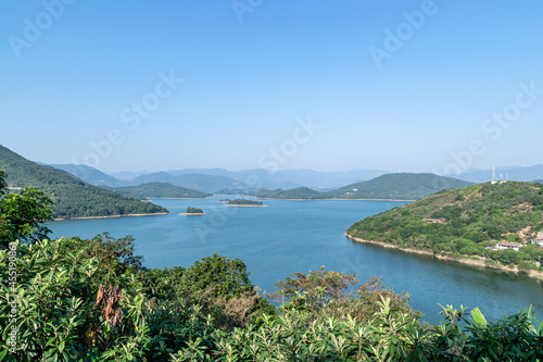 Under the blue sky, the lake is surrounded by mountains and forests