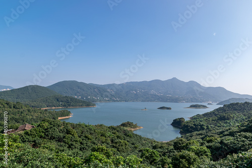 Under the blue sky, the lake is surrounded by mountains and forests