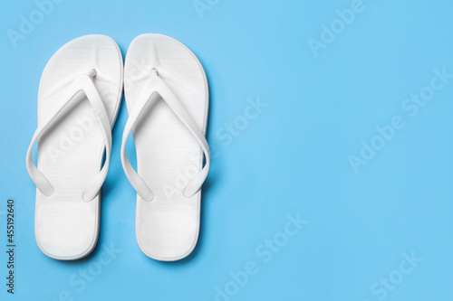 Stylish flip flops on light blue background, flat lay. Space for text