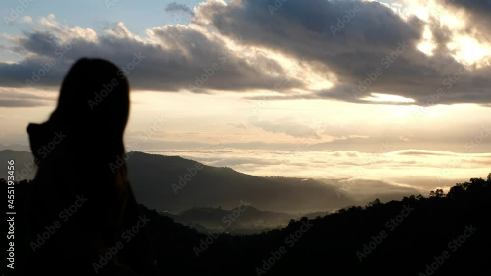 Silhouette blurred of a female traveler looking at a beautiful mountains view on foggy day Silhouette blurred of a female traveler looking at a beautiful mountains view on foggy day
