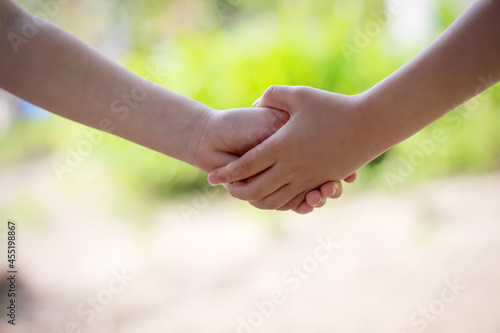 Asian girl shaking hand with child girl friend childhood background © Amphawan