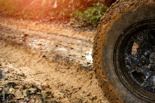 Part of the muddy off-road wheels On a muddy road in the evergreen forest adventure concept forest tourism concept