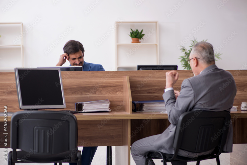 Two male employees working in the office Two male employees working in the office