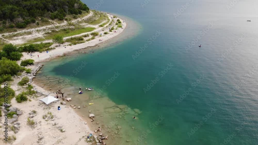 Tourist relaxing on sandy beach from transparent Canyon Lake in Texas Hill during sunlight - Idyllic shore in nature Tourist relaxing on sandy beach from transparent Canyon Lake in Texas Hill during sunlight - Idyllic shore in nature
