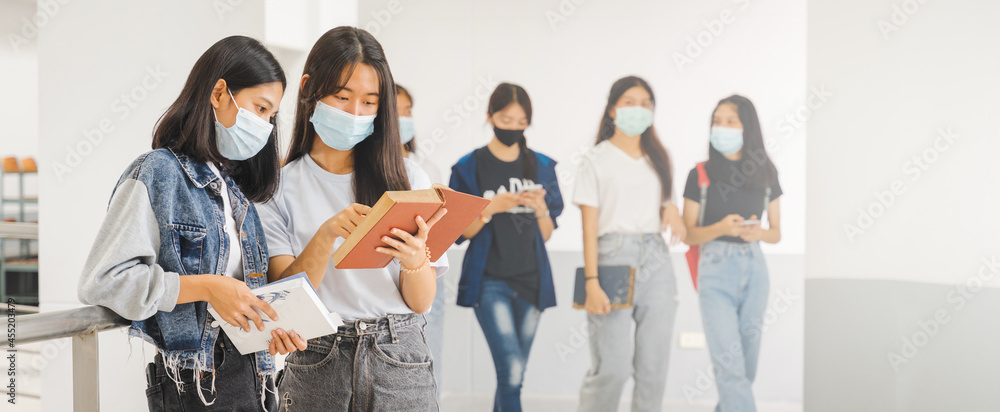 Asian college students back to school with protective face mask studying in the campus