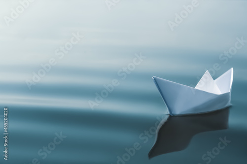 White paper boat floating on river, space for text © New Africa