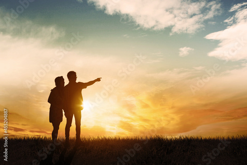 Young couple standing at the park at sunset time