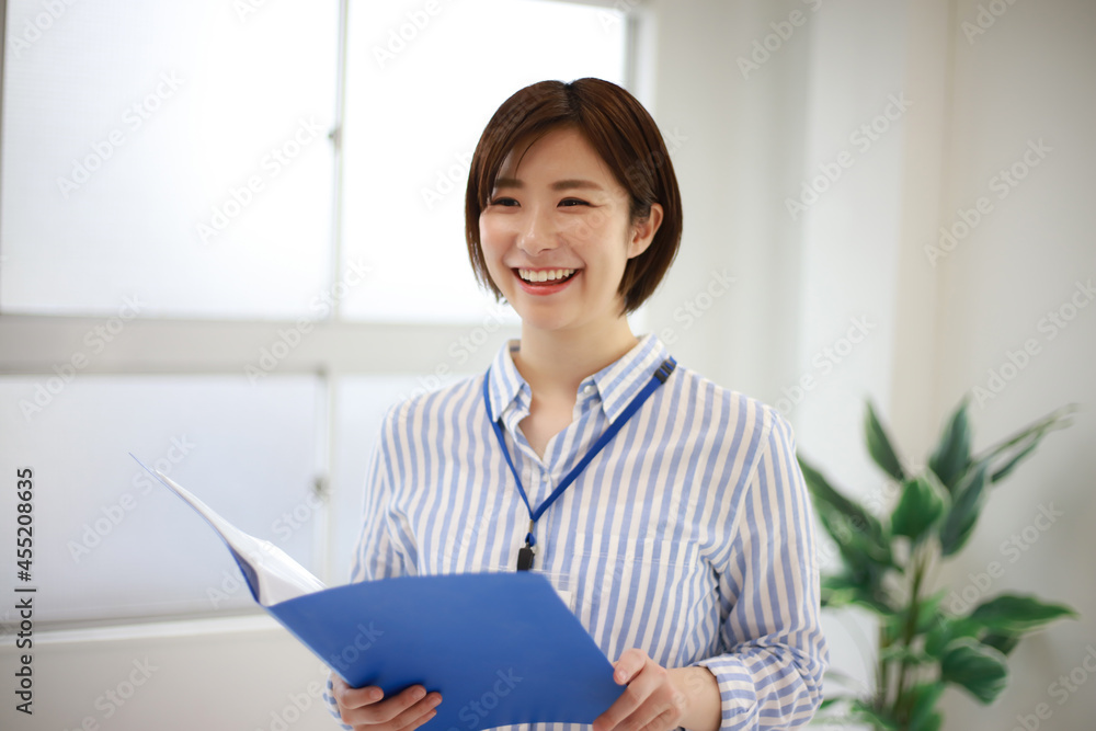 ファイルを持つ女性社員 ファイルを持つ女性社員