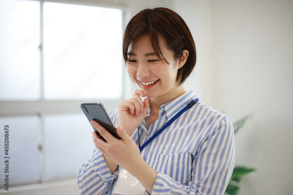 スマートフォンを持つ女性社員 スマートフォンを持つ女性社員