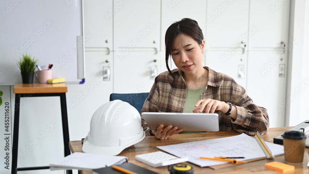 Female construction engineer working with digital tablet in working site.