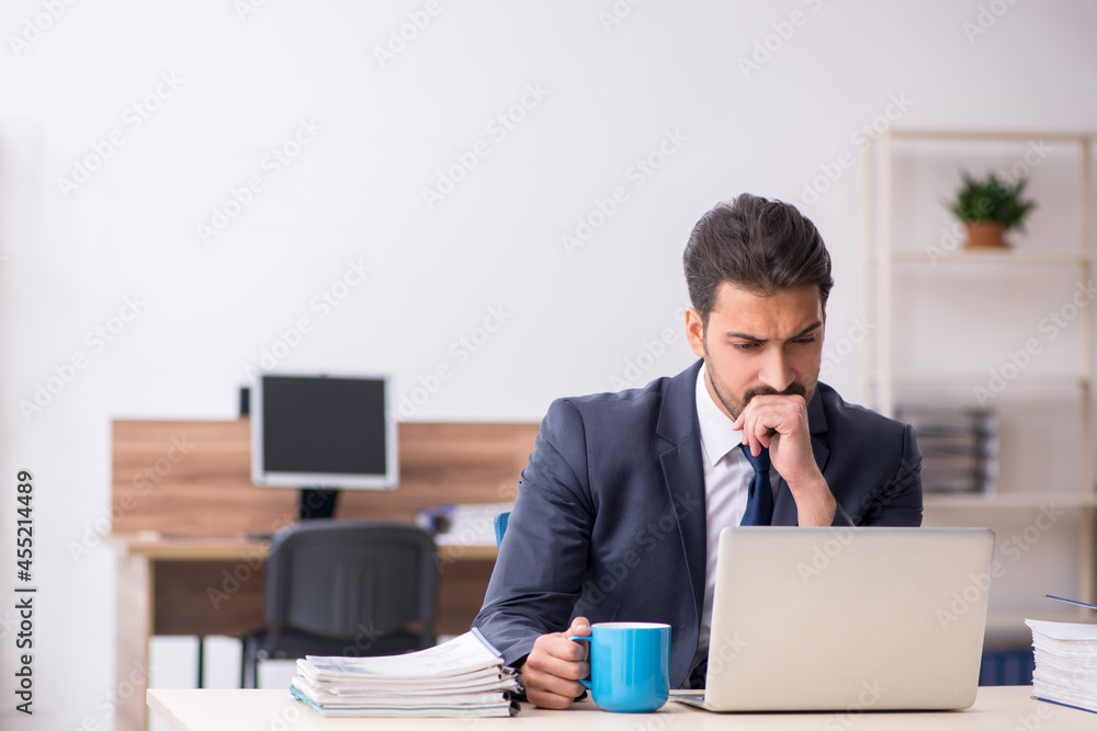 Young male employee drinking coffee during break Young male employee drinking coffee during break