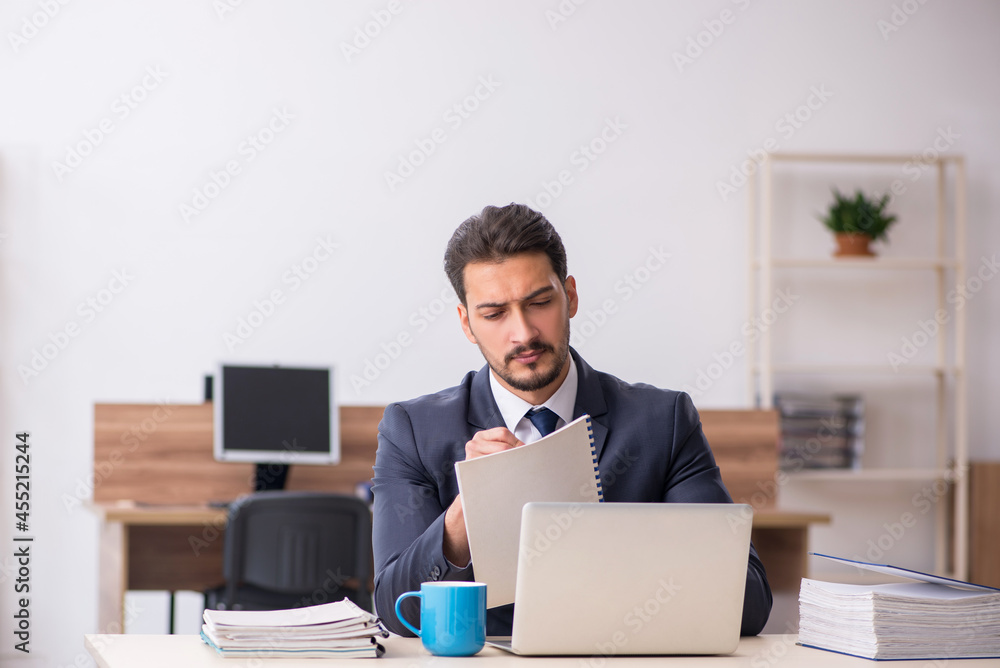 Young male employee sitting at workplace Young male employee sitting at workplace