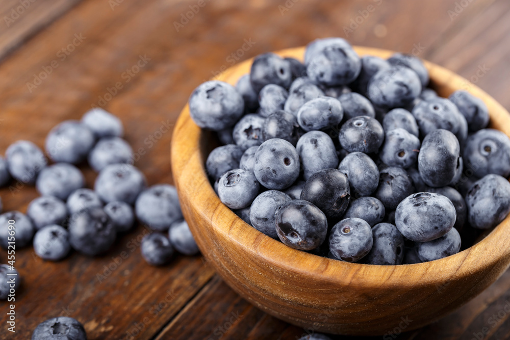 Freshly picked blueberries in wooden bowl on a wooden table. Freshly picked blueberries in wooden bowl on a wooden table.