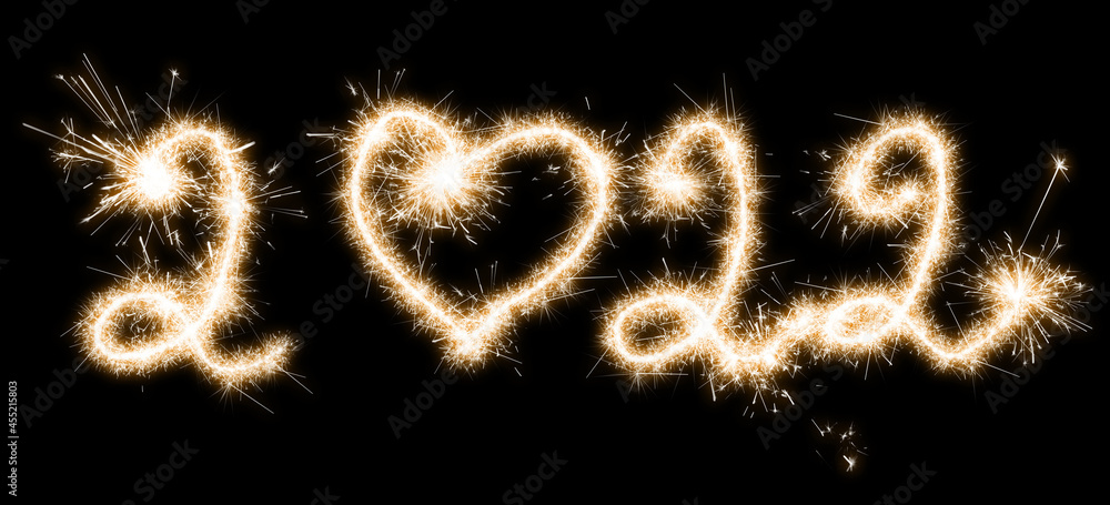 The 2022 lettering is made with sparklers isolated on black background