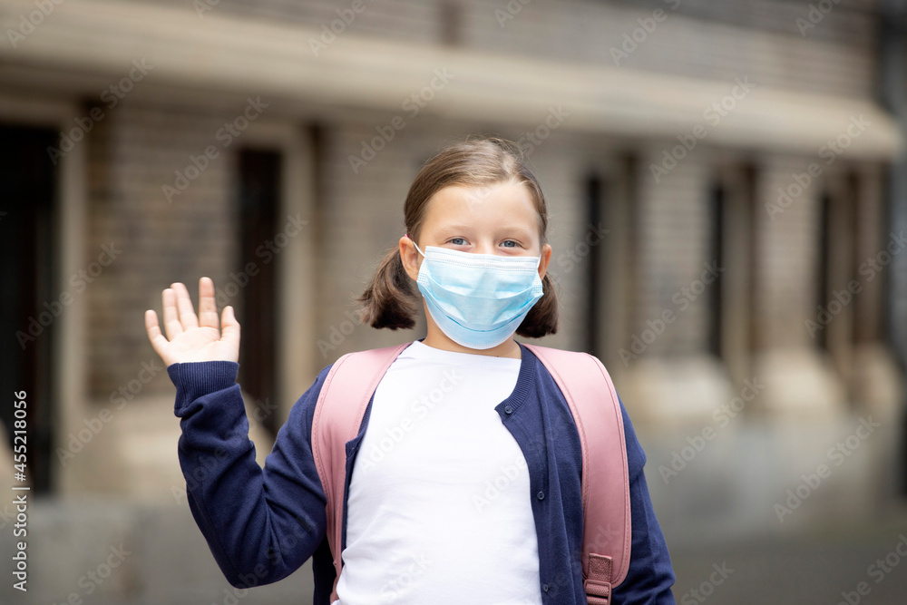 School girl with face mask in front of her school School girl with face mask in front of her school