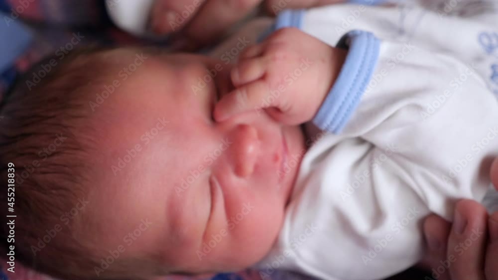 Close-up portrait of a newborn baby in the hospital, dad holding the baby's hand. Close-up portrait of a newborn baby in the hospital, dad holding the baby's hand.