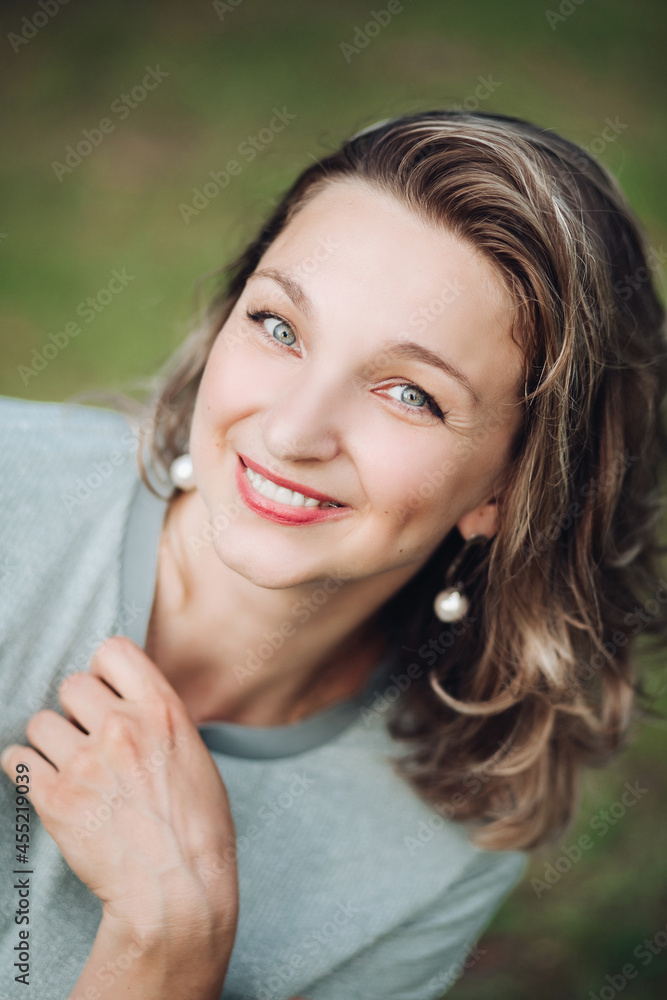 Optimistic beautiful woman smiling at camera.Blurred background. Optimistic beautiful woman smiling at camera.Blurred background.