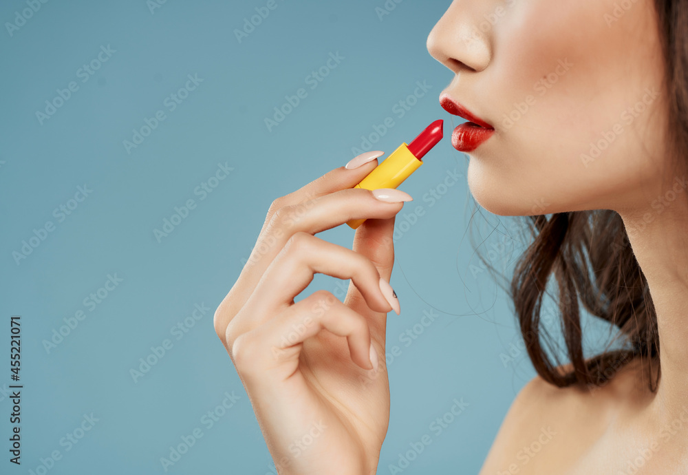 woman with bare shoulders lipstick cosmetics blue background